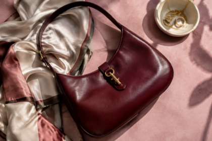 Borsa a spalla senza marchi in pelle bordeaux su tessuto rosa con un foulard